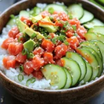Für die würzige Thunfisch-Sushi-Bowls benötigst du: - 1 Tasse Sushi-Reis - 1 ½ Tassen Wasser - 200g Sushi-Qualität Thunfisch, gewürfelt - 2 Esslöffel Mayonnaise (vorzugsweise japanische Kewpie) - 1 Esslöffel Sriracha - 1 Teelöffel Sesamöl - 1 Avocado, in Scheiben geschnitten - ½ Gurke, dünn geschnitten - 2 Frühlingszwiebeln, in Ringe geschnitten - 1 Esslöffel Sesamsamen - Nori-Blätter, in Streifen geschnitten (zur Garnitur) - Sojasauce, zum Servieren (optional) Die Auswahl der besten Zutaten ist wichtig. Verwende frischen Thunfisch von hoher Qualität. Achte darauf, dass er für Sushi geeignet ist. Der Geschmack wird dadurch viel besser. Wähle auch reife Avocados. Sie geben eine cremige Textur. Bei der Mayonnaise ist Kewpie eine gute Wahl. Sie hat einen besonderen Geschmack. Frische Gurken sorgen für einen knackigen Biss. Frühlingszwiebeln bringen Frische in die Schalen. Es gibt viele Möglichkeiten, die Zutaten zu variieren. Du kannst Lachs anstelle von Thunfisch verwenden. Auch Tofu ist eine gute Wahl für eine vegetarische Version. Für einen scharfen Kick kannst du mehr Sriracha hinzufügen. Wenn du keinen Sushi-Reis hast, probiere Quinoa oder normalen Reis. Nori-Blätter sind nicht zwingend nötig, aber sie geben einen tollen Crunch. Sojasauce kannst du auch durch Tamari ersetzen, wenn du glutenfrei kochen möchtest. Zuerst spülen Sie den Sushi-Reis gründlich. Das Wasser sollte klar bleiben. Dies entfernt überschüssige Stärke. So wird der Reis schön und klebrig. Kombinieren Sie den Reis mit Wasser in einem Topf. Bringen Sie das Wasser zum Kochen und reduzieren Sie dann die Hitze. Decken Sie den Topf ab und lassen Sie den Reis 18 bis 20 Minuten köcheln. Wenn das Wasser weg ist, nehmen Sie den Topf vom Herd. Lassen Sie den Reis noch zehn Minuten ruhen. Das Dampf hilft dem Reis, perfekt zu werden. Während der Reis kocht, bereiten Sie die Thunfisch-Mischung vor. Nehmen Sie eine Schüssel und fügen Sie den gewürfelten Thunfisch hinzu. Geben Sie die Mayonnaise, Sriracha und Sesamöl dazu. Mischen Sie alles gut. Der Thunfisch sollte gleichmäßig bedeckt sein. So wird jeder Bissen würzig und lecker. Lassen Sie die Mischung kurz stehen, damit die Aromen gut durchziehen. Jetzt ist es Zeit zum Anrichten! Lockern Sie den gekochten Sushi-Reis mit einer Gabel auf. Sie können nach Belieben etwas Salz hinzufügen. Teilen Sie den Reis gleichmäßig auf zwei Schalen auf. Geben Sie die würzige Thunfisch-Mischung auf den Reis. Fügen Sie die geschnittene Avocado und Gurken hinzu. Streuen Sie die Frühlingszwiebeln und Sesamsamen darüber. Garnieren Sie alles mit Nori-Streifen für extra Crunch. Servieren Sie die Bowls mit Sojasauce, wenn Sie möchten. Das bringt den Geschmack auf ein neues Level. Für das vollständige Rezept schauen Sie sich die [Full Recipe] an. Um die perfekte Reis-Konsistenz zu erreichen, spülen Sie den Sushi-Reis gut ab. So entfernen Sie die Stärke. Achten Sie darauf, dass das Wasser klar bleibt. Kochen Sie dann den Reis mit der richtigen Wassermenge. Lassen Sie ihn nach dem Kochen 10 Minuten ruhen. Der Dampf hilft dem Reis, locker und zart zu werden. Experimentieren Sie mit verschiedenen Zutaten. Fügen Sie frische Kräuter wie Koriander oder Minze hinzu. Für mehr Schärfe können Sie mehr Sriracha verwenden. Sie können auch Mango oder Ananas für eine süße Note probieren. Wenn Sie es herzhaft mögen, sind geröstete Nüsse eine tolle Ergänzung. Die Präsentation macht viel aus. Verwenden Sie große Schalen, um die Zutaten gut zur Geltung zu bringen. Schichten Sie den Reis zuerst, gefolgt von der Thunfisch-Mischung. Fügen Sie die Avocado und Gurke in schönen Mustern hinzu. Streuen Sie Sesamsamen und Nori-Streifen obenauf. Ein schön angerichteter Teller macht das Essen noch mehr Spaß. {{image_4}} Wenn Sie eine vegetarische oder vegane Option suchen, können Sie den Thunfisch einfach ersetzen. Eine gute Wahl sind gewürfelte Avocado oder Tofu. Beide Zutaten bieten eine cremige Textur. Für zusätzlichen Geschmack können Sie sie mit einer würzigen Mayo oder einer Sojasauce kombinieren. Sie können auch marinierten Tempeh verwenden. Tempeh hat einen nussigen Geschmack und nimmt Aromen gut auf. Die Saucen machen eine große Unterschied. Sie können die Sriracha-Mayonnaise variieren. Probieren Sie eine Erdnusssauce für einen anderen Twist. Auch eine Sesamsauce passt gut. Haben Sie Spaß mit Toppings! Fügen Sie geröstete Nüsse oder frische Kräuter hinzu. Frischer Koriander oder Minze verleiht einen frischen Geschmack. Auch eingelegte Karotten sind eine tolle Ergänzung und bringen eine süß-saure Note. Nutzen Sie saisonale Zutaten, um die Bowls noch interessanter zu machen. Im Sommer sind frische Tomaten oder Mangos eine tolle Wahl. Im Herbst können Sie Kürbiswürfel oder geröstete Süßkartoffeln verwenden. Diese Zutaten bringen Farbe und Nährstoffe. Sie können auch verschiedene Blattgemüse hinzufügen. Spinat oder Rucola geben einen frischen Biss. Experimentieren Sie mit verschiedenen Kombinationen, um Ihre perfekten Sushi-Bowls zu finden. Lagern Sie Ihre Würzige Thunfisch-Sushi-Bowls gut. Verwenden Sie einen luftdichten Behälter. Das hält den Reis frisch und den Thunfisch sicher. Lassen Sie die Schalen zuerst abkühlen. Dies verhindert Kondensation und macht den Reis matschig. Wenn Sie Reste haben, stellen Sie sicher, dass der Thunfisch nicht länger als zwei Stunden bei Raumtemperatur bleibt. Die Würzigen Thunfisch-Sushi-Bowls bleiben im Kühlschrank etwa zwei Tage frisch. Der Reis kann jedoch trocken werden. Achten Sie darauf, die Schalen rechtzeitig zu essen. Wenn Sie die Schalen länger aufbewahren, verlieren sie ihren Geschmack. Den Thunfisch sollten Sie nicht einfrieren. Das verändert die Textur und den Geschmack. Um die Schalen wieder warm zu machen, nutzen Sie die Mikrowelle. Geben Sie den Reis in eine mikrowellengeeignete Schüssel und fügen Sie einen Spritzer Wasser hinzu. Decken Sie die Schüssel ab. Erwärmen Sie sie in 30-Sekunden-Intervallen, bis der Reis warm ist. Achten Sie darauf, den Thunfisch nicht zu erhitzen. Er schmeckt am besten, wenn er kalt bleibt. Für das vollständige Rezept schauen Sie sich die [Full Recipe] an. Um die perfekte Konsistenz für den Sushi-Reis zu erreichen, spülen Sie den Reis gründlich ab. Nutzen Sie kaltes Wasser, bis es klar bleibt. Dies entfernt überschüssige Stärke. Kochen Sie den Reis dann mit der richtigen Menge Wasser. Lassen Sie den Reis nach dem Kochen 10 Minuten ruhen. Das Dämpfen sorgt für eine lockere, klebrige Textur. Ja, gefrorener Thunfisch ist eine gute Option für Sushi. Achten Sie darauf, dass der Thunfisch von hoher Qualität ist. Lassen Sie den Thunfisch vor der Zubereitung im Kühlschrank auftauen. So bleibt der Geschmack frisch und die Textur gut. Verwenden Sie gefrorenen Thunfisch schnell, um die besten Ergebnisse zu erzielen. Zu Spicy Tuna Sushi Bowls passen viele leckere Beilagen. Hier sind einige Vorschläge: - Edamame - Miso-Suppe - Tempura-Gemüse - Nori-Snacks - Eingelegter Ingwer Diese Beilagen ergänzen die Sushi-Bowls perfekt und bieten mehr Vielfalt. Wenn Sie mehr Ideen brauchen, schauen Sie sich den Full Recipe an. In diesem Blogpost haben wir die besten Zutaten für Spicy Tuna Sushi Bowls besprochen. Ich habe erklärt, wie man Sushi-Reis zubereitet und eine würzige Thunfisch-Mischung erstellt. Tipps für den perfekten Reis und Variationen haben wir ebenfalls behandelt. Schließlich haben wir auch wichtige Lagerungshinweise und nützliche FAQs geteilt. Deine nächste Spicy Tuna Sushi Bowl wird sicher ein Hit! Nutze die Vorschläge, um zu experimentieren und deine eigene Note hinzuzufügen. Viel Spaß beim Kochen!