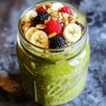 Die Zutaten für deine High-Protein Matcha Overnight Oats sind einfach und leicht zu finden. Du brauchst: - 1 Tasse Haferflocken - 1 Tasse ungesüßte Mandelmilch (oder Milch nach Wahl) - 1 Esslöffel Matcha-Grünteepulver - 1 Esslöffel Chiasamen - 1 Portion Vanille-Proteinpulver (pflanzenbasiert oder Molkenprotein) - 1 Esslöffel Honig oder Ahornsirup (optional, für zusätzliche Süße) - 1/2 Teelöffel Vanilleextrakt - Frisches Obst (z.B. in Scheiben geschnittene Banane, Beeren) für das Topping - Nüsse oder Samen zur Dekoration (z.B. Mandeln, Sonnenblumenkerne) Jede Zutat in diesem Rezept hat ihre eigenen Vorteile. Haferflocken sind reich an Ballaststoffen und helfen, den Magen voll zu halten. Die ungesüßte Mandelmilch gibt dir gesunde Fette und ist kalorienarm. Matcha ist voller Antioxidantien und gibt dir einen sanften Energieschub. Chiasamen sind kleine Kraftpakete. Sie sind reich an Omega-3-Fettsäuren und unterstützen die Verdauung. Das Vanille-Proteinpulver hilft, Muskeln zu bauen und zu reparieren. Honig oder Ahornsirup fügt einen natürlichen Süßstoff hinzu, was gut für den Geschmack ist. Frisches Obst bringt Vitamine und zusätzliche Süße. Nüsse oder Samen sorgen für einen angenehmen Crunch und sind ebenfalls gesund. Falls du einige Zutaten nicht hast oder magst, gibt es Alternativen. Statt Haferflocken kannst du Quinoa verwenden. Für die Milch kannst du auch Soja- oder Kokosnussmilch nehmen. Anstelle von Matcha kann grüner Tee verwendet werden, wenn du keinen Matcha magst. Chiasamen lassen sich durch Leinsamen ersetzen. Bei der Wahl des Proteinpulvers gibt es viele Optionen, sogar ohne Geschmack. Wenn du keinen Honig oder Ahornsirup willst, kannst du auch einen anderen Süßstoff verwenden. Du kannst alle Früchte nach deinem Geschmack wählen. Am Ende ist es dein Frühstück! Um die trockenen Zutaten vorzubereiten, nehme ich eine große Rührschüssel. Ich gebe 1 Tasse Haferflocken hinein. Dazu kommen die 1 Esslöffel Chiasamen und 1 Esslöffel Matcha-Grünteepulver. Dann füge ich 1 Portion Vanille-Proteinpulver hinzu. Ich rühre alles gut um, bis die Mischung gleichmäßig aussieht. Das sorgt dafür, dass jeder Bissen voller Geschmack ist. Jetzt bereite ich die flüssige Mischung vor. In einer separaten Schüssel gebe ich 1 Tasse ungesüßte Mandelmilch. Wenn ich möchte, kann ich auch eine andere Milch wählen. Dann füge ich 1 Esslöffel Honig oder Ahornsirup hinzu. Das ist optional, aber ich mag die extra Süße. Ich gebe auch 1/2 Teelöffel Vanilleextrakt hinein. Mit einem Schneebesen verrühre ich alles gut, bis es gleichmäßig ist. Jetzt ist es Zeit, die beiden Mischungen zu kombinieren. Ich gieße die flüssige Mischung langsam zu den trockenen Zutaten. Während ich das mache, rühre ich ständig um. So wird alles gleichmäßig verteilt. Wenn alles gut vermischt ist, teile ich die Mischung in Gläser oder Behälter. Ich verschließe die Behälter und stelle sie über Nacht in den Kühlschrank. Mindestens 4 Stunden sind nötig, damit die Haferflocken quellen. Am nächsten Morgen rühre ich alles gut durch und garniere es mit frischem Obst und Nüssen. So habe ich ein gesundes, leckeres Frühstück! Um die besten Overnight Oats zu machen, folge diesen einfachen Tipps: - Gleiche Teile: Verwende gleiche Teile Haferflocken und Flüssigkeit. So bleiben die Oats cremig. - Chiasamen hinzufügen: Chiasamen sorgen für eine tolle Textur und mehr Protein. - Frisch mixen: Mische die trockenen Zutaten gut, bevor du die Flüssigkeit hinzufügst. - Kühlschrank: Lass die Mischung über Nacht im Kühlschrank. So quellen die Oats gut auf. - Schichten: Schichte die Oats in ein Glas. Das sieht gut aus und macht Spaß. Einige Fehler können das Ergebnis ruinieren. Hier sind die häufigsten: - Zu viel Flüssigkeit: Wenn du zu viel Milch nimmst, werden die Oats matschig. - Nicht genug Zeit: Lass die Mischung mindestens 4 Stunden ziehen. - Falsche Behälter: Verwende luftdichte Behälter, damit die Oats frisch bleiben. - Vergessen, zu rühren: Rühre die Oats vor dem Servieren gut durch. So verteilen sich die Zutaten gleichmäßig. Die Portionen sind wichtig für eine ausgewogene Ernährung: - Portionsgröße: Eine Portion sind etwa 1/2 bis 1 Tasse. - Toppings: Toppe deine Oats mit frischem Obst, Nüssen oder Samen. Das gibt mehr Geschmack. - Zum Mitnehmen: Verwende ein Einmachglas für ein schnelles Frühstück unterwegs. - Variationen: Probiere verschiedene Obstsorten oder Toppings, um die Oats spannend zu halten. Mit diesen Tipps bereitest du sicher leckere und nahrhafte Overnight Oats zu, die dir Energie für den Tag geben. {{image_4}} Du kannst die Geschmacksrichtung deiner High-Protein Matcha Overnight Oats ganz einfach ändern. Nutze verschiedene Sorten von Proteinpulver. Probiere Schokolade, Erdbeere oder sogar Kokosnuss. Jedes Pulver bringt einen neuen Geschmack. Du kannst auch andere Teesorten verwenden. Grüner Tee, Jasmin oder sogar Rooibos können interessant sein. Experimentiere und finde deinen Liebling. Toppings machen dein Frühstück noch spannender! Füge frisches Obst wie Beeren, Äpfel oder Birnen hinzu. Diese bringen Frische und Süße. Nüsse wie Mandeln oder Walnüsse bieten einen knackigen Biss. Auch Samen wie Chiasamen oder Leinsamen erhöhen den Nährstoffgehalt. Honig oder Kokosraspeln können auch eine süße Note hinzufügen. Du kannst sogar einen Schuss Erdnussbutter für extra Protein verwenden! Wenn du spezielle diätetische Anforderungen hast, gibt es viele Möglichkeiten. Verwende Haferflocken ohne Gluten für eine glutenfreie Option. Ersetze die Mandelmilch durch Kokosmilch für eine cremige Textur. Veganer können pflanzenbasiertes Proteinpulver nutzen. Wenn du weniger Zucker möchtest, lass den Honig weg. Deine Overnight Oats bleiben lecker und nahrhaft, egal welche Anpassungen du vornimmst. Die High-Protein Matcha Overnight Oats sind im Kühlschrank bis zu 5 Tage haltbar. Das gibt dir die Freiheit, sie im Voraus zuzubereiten. Du kannst sie jeden Tag genießen, ohne viel Zeit in der Küche zu verbringen. Bewahre die Overnight Oats in einem luftdichten Behälter auf. Das hilft, die Frische zu bewahren und unerwünschte Gerüche zu vermeiden. Stelle sicher, dass der Behälter gut verschlossen ist, bevor du ihn in den Kühlschrank stellst. Achte darauf, dass die Oats immer kühl gelagert werden. Du kannst die Overnight Oats leicht im Voraus zubereiten. Mache mehrere Portionen auf einmal und teile sie in Gläser oder Behälter auf. So hast du ein schnelles Frühstück für die ganze Woche. Wenn du die Oats portionierst, füge das Obst und die Nüsse erst kurz vor dem Servieren hinzu. So bleiben sie frisch und knackig. Um die Overnight Oats gesünder zu machen, können Sie verschiedene Zutaten wählen. Verwenden Sie zum Beispiel ungesüßte Mandelmilch oder Hafermilch. Fügen Sie mehr Chiasamen oder Leinsamen hinzu, um Ballaststoffe zu erhöhen. Sie können auch frisches Obst wie Beeren oder Äpfel verwenden. Diese Früchte sorgen für Vitamine und Mineralien. Versuchen Sie es auch ohne Honig oder mit weniger Süße. So bleibt der Zuckergehalt niedrig. Ja, Sie können die Zutaten ganz nach Ihrem Geschmack anpassen. Mögen Sie Erdnussbutter? Fügen Sie einen Löffel hinzu! Anstelle von Matcha können Sie Kakaopulver verwenden. Wenn Sie kein Proteinpulver haben, lassen Sie es weg oder verwenden Sie Joghurt. Seien Sie kreativ! Überlegen Sie, welche Aromen Ihnen gefallen. So machen Sie das Rezept einzigartig für sich. Um die Konsistenz zu verbessern, achten Sie auf das Verhältnis von Hafer zu Flüssigkeit. Wenn die Mischung zu dick ist, fügen Sie mehr Milch hinzu. Wenn sie zu dünn ist, mehr Hafer oder Chiasamen verwenden. Lassen Sie die Oats ausreichend quellen. Mindestens vier Stunden im Kühlschrank sind wichtig. Wenn Sie es am Morgen servieren, rühren Sie es gut um. So wird es cremiger und gleichmäßiger. In diesem Artikel haben wir die besten Zutaten für Overnight Oats besprochen. Wir haben die Nährstoffe, gesundheitlichen Vorteile und Alternativen betrachtet. Die Schritt-für-Schritt-Anleitung hilft dir bei der Zubereitung. Tipps und Tricks zeigen, wie du Fehler vermeidest und die perfekten Portionen wählst. Variationen ermöglichen interessante Geschmackserlebnisse. Auch die Aufbewahrung und häufige Fragen sind wichtig. Nutze dieses Wissen für gesunde und leckere Overnight Oats. Werde kreativ und genieße jeden Bissen!