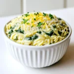 - 1 Tasse Orzo-Pasta - 2 Tassen frischer Spinat, grob gehackt - 1/2 Tasse frisch geriebener Parmesan Die Orzo-Pasta ist die Grundlage dieses Gerichts. Sie kocht schnell und hat eine tolle Textur. Der frische Spinat bringt Farbe und einen gesunden Kick. Parmesan ist der Star, der alles zusammenbindet und dem Gericht seinen cremigen Geschmack verleiht. - 2 Esslöffel Olivenöl - 1 Teelöffel italienische Gewürzmischung - Salz und Pfeffer nach Geschmack Olivenöl sorgt für eine reichhaltige Basis. Die italienische Gewürzmischung gibt dem Gericht Tiefe. Salz und Pfeffer bringen die Aromen zum Leuchten. - 4 Tassen Gemüsebrühe - 1/4 Tasse Sahne (oder pflanzliche Sahne) Gemüsebrühe ist wichtig für den Geschmack. Sie gibt der Orzo-Pasta ein würziges Aroma. Sahne macht das Gericht cremig und zart. Wenn du eine pflanzliche Option verwendest, bleibt es trotzdem lecker und vegan. Beginne mit der Vorbereitung der Zutaten. Hacke vier Knoblauchzehen fein. Das gibt dem Gericht einen tollen Geschmack. Nimm zwei Tassen frischen Spinat und hacke ihn grob. Der Spinat wird später schön weich und gibt Farbe. Erhitze zwei Esslöffel Olivenöl in einem großen Topf bei mittlerer Hitze. Füge den gehackten Knoblauch hinzu und sautieren ihn für etwa eine Minute. Achte darauf, dass der Knoblauch nicht braun wird. Jetzt ist es Zeit, die Orzo-Pasta hinzuzufügen. Röste die Orzo-Pasta für zwei Minuten. Rühre ständig, damit sie nicht anklebt. Gieße vier Tassen Gemüsebrühe in den Topf und bringe alles zum Kochen. Reduziere die Hitze und lasse die Mischung ohne Deckel für acht bis zehn Minuten köcheln. Die Orzo-Pasta sollte al dente sein und die meiste Flüssigkeit aufnehmen. Rühre den grob gehackten Spinat unter und lasse ihn zwei Minuten wilt. Senke die Hitze und füge eine halbe Tasse frisch geriebenen Parmesan und ein Viertel Tasse Sahne hinzu. Rühre gut um, bis alles cremig ist. Würze das Gericht mit italienischer Gewürzmischung, Salz und Pfeffer nach Geschmack. Lass es zwei bis drei Minuten ruhen, bevor du es servierst. Um angebrannte Pasta zu vermeiden, rühre die Orzo gut um. Röste sie für zwei Minuten, damit sie nicht kleben bleibt. Die Hitze sollte nicht zu hoch sein. Das hilft, den Knoblauch aromatisch, aber nicht braun zu halten. Für die perfekte Konsistenz achte darauf, die Brühe langsam hinzuzufügen. Wenn die Orzo fast gar ist, rühre den Spinat ein. So bleibt er schön grün und knackig. Nach dem Hinzufügen von Parmesan und Sahne, lasse das Gericht kurz ruhen. Das macht es cremiger. Nutze die Kochzeit clever. Während die Orzo kocht, kannst du die Zutaten vorbereiten. Hacke den Knoblauch und Spinat, während das Wasser erhitzt. So sparst du Zeit. Außerdem hast du mehr Zeit zum Genießen, wenn das Essen fertig ist. Für das Servieren empfehle ich, das Orzo in Schalen zu geben. Garniere es mit frischer Zitronenschale und Petersilie. Das sieht toll aus und gibt einen frischen Geschmack. Du kannst auch etwas mehr Parmesan darüber streuen, um es noch leckerer zu machen. {{image_4}} Du kannst das Gericht leicht anpassen. Füge Pilze oder Zucchini hinzu, um mehr Geschmack zu bekommen. Pilze bringen eine herzhafte Note. Zucchini sorgt für eine frische, knackige Textur. Achte darauf, das Gemüse klein zu schneiden. So garen sie gleichmäßig. Das Gemüse kannst du beim Sautieren mit dem Knoblauch hinzufügen. So entfalten sich die Aromen besser. Möchtest du mehr Protein? Integriere Hähnchen oder Garnelen in dein Gericht. Hähnchenbrust kannst du in Würfel schneiden und anbraten. Die Garnelen fügst du einfach in der letzten Kochphase hinzu. Beide Optionen machen das Gericht nahrhafter und sättigender. Achte darauf, die Garzeit anzupassen. Hähnchen braucht länger als Garnelen. So bleibt alles perfekt zart und saftig. Für eine vegane Variante nutze pflanzlichen Parmesan und Sahne. Das sorgt für den gleichen cremigen Geschmack. Du kannst auch Cashewcreme verwenden, um noch mehr Tiefe zu erreichen. Achte darauf, dass die Brühe ebenfalls pflanzlich ist. Diese Anpassungen machen das Gericht für jeden zugänglich. So kann jeder den Genuss von One-Pot Garlic Parmesan Orzo mit Spinach erleben. Um die Reste von One-Pot Garlic Parmesan Orzo mit Spinat richtig zu lagern, lasse das Gericht zuerst abkühlen. Fülle es dann in einen luftdichten Behälter. So bleibt der Geschmack frisch. Im Kühlschrank hält sich der Orzo bis zu drei Tage. Wenn du ihn aufwärmst, füge etwas Brühe oder Wasser hinzu. Das hilft, die Cremigkeit wiederherzustellen. Um das Gericht einzufrieren, lasse es ganz abkühlen. Gib den Orzo in einen gefrierfesten Behälter oder einen Gefrierbeutel. Versuche, so viel Luft wie möglich zu entfernen. So bleibt der Geschmack besser erhalten. Der gefrorene Orzo kann bis zu drei Monate aufbewahrt werden. Zum Aufwärmen, tau das Gericht über Nacht im Kühlschrank auf. Erhitze es dann in einer Pfanne oder Mikrowelle, bis es heiß ist. Um die Frische zu überprüfen, schaue auf die Farbe und den Geruch. Wenn der Orzo seltsam riecht oder die Farbe sich verändert hat, wirf ihn weg. Auch die Konsistenz ist wichtig. Wenn er schleimig oder trocken erscheint, ist es Zeit, ihn zu entsorgen. Vertrauen Sie auf Ihre Sinne, um die beste Qualität zu sichern. Die Zubereitungszeit beträgt nur 10 Minuten. Die gesamte Kochzeit ist etwa 15 Minuten. Das Gericht ist schnell und einfach. Perfekt für ein schnelles Abendessen! Ja, du kannst andere Käsesorten nutzen. Feta-Käse oder Gouda sind gute Alternativen. Sie geben dem Gericht einen anderen Geschmack. Experimentiere mit deinem Lieblingskäse! Das Originalrezept ist nicht glutenfrei. Du kannst jedoch glutenfreie Orzo-Pasta verwenden. So passt das Gericht zu einer glutenfreien Diät. Achte darauf, glutenfreie Brühe zu wählen! Diese Anleitung zeigt, wie man ein schmackhaftes One-Pot Garlic Parmesan Orzo kocht. Wir haben die Hauptzutaten wie Orzo-Pasta, frischen Spinat und Parmesan betrachtet. Mit den richtigen Gewürzen und Flüssigkeiten gelingt das Gericht schnell und einfach. Ich habe Tipps zur Zubereitung, Zeitmanagement und Variationen geteilt, um es an deinen Geschmack anzupassen. Zum Schluss habe ich auch die besten Lagerungshinweise gegeben. Jetzt bist du bereit, dieses Gericht zu Hause zu genießen und mit Freunden zu teilen!