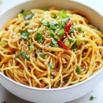 Für die Chili Garlic Noodles brauche ich frische, einfache Zutaten. Hier sind die Hauptbestandteile: - 200 g Eiernudeln - 2 Esslöffel Pflanzenöl - 4 Knoblauchzehen, fein gehackt - 1 rote Chili, fein geschnitten - 2 Esslöffel Sojasauce - 1 Esslöffel Chilipaste (optional) - 1 Esslöffel Sesamöl - 1 Esslöffel Reisessig - 1 Teelöffel Zucker - 2 Frühlingszwiebeln, gehackt Die Eiernudeln geben das Hauptgerüst für dieses Gericht. Sie sind lecker und schnell zu kochen. Knoblauch bringt den vollen Geschmack, während die rote Chili die richtige Schärfe liefert. Die Gewürze und Saucen machen die Chili Garlic Noodles besonders. Ich verwende: - Sojasauce für die Salzigkeit - Reisessig für eine frische Note - Sesamöl, um das Aroma zu verstärken - Chilipaste, wenn ich es schärfer mag - Zucker, um die Aromen auszubalancieren Diese Mischung sorgt für einen harmonischen Geschmack. Die Sojasauce und der Reisessig geben Tiefe. Die Garnierungen sind das i-Tüpfelchen für mein Gericht. Ich empfehle: - Frischer Koriander für Frische - Sesamsamen für Crunch - Gehackte Frühlingszwiebeln für Farbe und Geschmack Diese Zutaten machen die Chili Garlic Noodles nicht nur hübsch, sondern auch noch schmackhafter. Ein paar zusätzliche Chilischeiben oben drauf bringen Farbe und zeigen, dass es scharf ist! {{ingredient_image_2}} Um die Eiernudeln perfekt zuzubereiten, koche zuerst 200 g in einem großen Topf mit kochendem Wasser. Ich empfehle, die Nudeln nach den Anweisungen auf der Verpackung zu kochen, bis sie al dente sind. Das dauert normalerweise etwa 5 bis 7 Minuten. Achte darauf, die Nudeln danach gut abzugießen und beiseite zu stellen. So kannst du sicherstellen, dass sie nicht kleben. Jetzt kommt der spannende Teil! Erhitze 2 Esslöffel Pflanzenöl in einer großen Pfanne oder einem Wok bei mittlerer Hitze. Füge 4 fein gehackte Knoblauchzehen und 1 fein geschnittene rote Chili hinzu. Brate diese Mischung 1 bis 2 Minuten lang an, bis sie aromatisch ist. Achte darauf, dass der Knoblauch nicht verbrennt, denn das kann bitter schmecken. Jetzt kommen die gekochten Eiernudeln in die Pfanne. Vermenge sie gut mit dem Knoblauch und der Chili. Mische in einer kleinen Schüssel 2 Esslöffel Sojasauce, 1 Esslöffel Chilipaste, 1 Esslöffel Sesamöl, 1 Esslöffel Reisessig und 1 Teelöffel Zucker. Gieße diese Sauce über die Nudeln und mische alles gründlich. Gar die Mischung 2 bis 3 Minuten weiter, damit die Nudeln die Aromen aufnehmen. Kurz vor dem Servieren, hebe 2 gehackte Frühlingszwiebeln unter. Koche alles bei mittlerer Hitze. Das Gericht ist in insgesamt 20 Minuten fertig. Präsentiere die Nudeln in einer Schüssel. Dekoriere sie mit frischem Koriander und Sesamsamen. Ein paar zusätzliche Chilischeiben machen das Gericht noch schöner und schmackhafter. Um die besten Chili Garlic Noodles zu machen, achte auf die Nudeln. Koche sie al dente. So bleiben sie bissfest. Erhitze das Öl gut, bevor du den Knoblauch und die Chili hinzufügst. Das bringt mehr Geschmack. Mische die Sauce gut, damit sie sich gleichmäßig verteilt. Rühre alles regelmäßig um, damit die Nudeln nicht anbrennen. Ein häufiger Fehler ist, die Nudeln zu lange zu kochen. Das macht sie matschig. Achte darauf, dass der Knoblauch nicht verbrennt. Verbrannter Knoblauch gibt einen bitteren Geschmack. Verwende frische Chilis. Alte Chilis verlieren ihren Geschmack und ihre Schärfe. Wenn du die Sauce nicht gut vermischst, schmecken die Nudeln nicht gleichmäßig. Wenn du es schärfer magst, füge mehr frische Chilis hinzu. Du kannst auch mehr Chilipaste verwenden. Probiere, einen Spritzer Sriracha oder scharfe Sojasauce hinzuzufügen. Eine Prise Cayennepfeffer kann auch helfen. Experimentiere mit verschiedenen Chili-Sorten für neuen Geschmack. Pro Tipps Die richtige Chili wählen: Verwende frische Chilis für einen intensiveren Geschmack. Du kannst die Schärfe anpassen, indem du die Kerne entfernst oder mehr oder weniger Chili hinzufügst. Vorbereitung der Zutaten: Bereite alle Zutaten im Voraus vor. Das macht den Kochprozess schneller und einfacher, besonders wenn du mit hohen Temperaturen arbeitest. Variationen ausprobieren: Füge zusätzliches Gemüse wie Brokkoli oder Paprika hinzu, um das Gericht nahrhafter zu machen und mehr Farben auf den Teller zu bringen. Umami verstärken: Ein Schuss Fischsauce oder ein Teelöffel Miso kann den Umami-Geschmack vertiefen und das Gericht noch geschmackvoller machen. {{image_4}} Um Chili Garlic Noodles vegan zu machen, ersetze die Eiernudeln. Nutze einfach Reisnudeln oder Glasnudeln. Diese Optionen sind leicht und geschmackvoll. Achte darauf, dass die Sojasauce ohne tierische Produkte ist. Du kannst Gemüse nach Wahl hinzufügen. Zucchini, Paprika oder Brokkoli passen gut. Einfach in die Pfanne geben, während du den Knoblauch anbrätst. Wenn du Eier magst, füge ein Rührei hinzu. Mische es einfach mit den Nudeln. Das gibt zusätzliches Protein und Geschmack. Wenn du keine Eiernudeln nutzen willst, gibt es viele leckere Alternativen. Wie gesagt, Reisnudeln sind eine tolle Wahl. Auch Udon-Nudeln sind eine gute Option. Sie sind dick und nehmen die Sauce gut auf. Glutenfreie Nudeln gibt es auch, falls du glutenfrei kochen möchtest. Wenn du Reste von Chili Garlic Noodles hast, lagere sie in einem luftdichten Behälter. So bleiben sie frisch. Lass die Nudeln auf Raumtemperatur abkühlen, bevor du sie im Kühlschrank aufbewahrst. Diese Maßnahme hilft, die Textur der Nudeln zu bewahren. Reste halten sich gut für bis zu drei Tage. Um die Nudeln wieder warm zu machen, nutze eine Pfanne oder Mikrowelle. In der Pfanne kannst du etwas Öl hinzufügen und die Nudeln bei mittlerer Hitze erhitzen. Das sorgt für ein gleichmäßiges Erwärmen. Wenn du die Mikrowelle verwendest, decke die Nudeln ab, um Austrocknung zu vermeiden. Erwärme sie in kurzen Intervallen und rühre sie zwischendurch um. Chili Garlic Noodles sind im Kühlschrank etwa drei Tage haltbar. Achte darauf, sie gut zu verpacken, um Geruchsübertragung zu vermeiden. Wenn du die Nudeln länger aufbewahren möchtest, friere sie ein. So halten sie sich bis zu drei Monate. Vor dem Verzehr einfach über Nacht im Kühlschrank auftauen. Die Schärfe der Chili Garlic Noodles hängt von der Menge der Chili ab, die du verwendest. Eine rote Chili gibt einen milden Kick. Wenn du mehr Schärfe magst, füge mehr Chili oder Chilipaste hinzu. Du kannst die Menge einfach nach deinem Geschmack anpassen. So kannst du deine perfekte Schärfe finden. Chili Garlic Noodles findet man oft in asiatischen Restaurants. Viele Orte bieten diese Nudeln als Teil ihrer Speisekarte an. Du kannst sie auch in Food-Trucks oder auf Märkten finden, wo sie frisch zubereitet werden. Wenn du Lust hast, sie zu Hause zu machen, ist das eine tolle Option. So hast du die Kontrolle über die Zutaten und die Schärfe. Ja, du kannst Chili Garlic Noodles im Voraus zubereiten. Koche die Nudeln und bereite die Sauce vor. Bewahre alles getrennt im Kühlschrank auf. Wenn du bereit bist, sie zu essen, erwärme die Nudeln und mische sie mit der Sauce. So bleiben die Nudeln frisch und lecker. Chili Garlic Noodles sind einfach und lecker. Wir haben die Hauptzutaten, Gewürze und Saucen sowie empfohlene Garnierungen besprochen. Du hast gelernt, wie man die Eiernudeln vorbereitet und das Gericht kombiniert. Wichtig sind auch Tipps, um Fehler zu vermeiden und eine schärfere Variante zu schaffen. Denke an die Variationen, etwa die vegane Version oder zusätzliche Zutaten. Die richtige Lagerung ist ebenfalls entscheidend. Nutze das Wissen aus diesen Tipps, um deine Chili Garlic Noodles perfekt zuzubereiten und zu genießen. Jeder Biss lohnt sich!