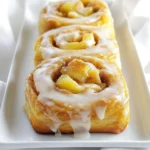 Um die besten Apfelkuchen Zimtschnecken zu machen, brauchst du folgende Zutaten: - 2 Tassen Weizenmehl - 3 Esslöffel Zucker - 1 Päckchen (2 1/4 Teelöffel) Trockenhefe - 1 Teelöffel gemahlener Zimt - 1/2 Teelöffel Salz - 1/2 Tasse warme Milch (110°F/45°C) - 1/4 Tasse ungesalzene Butter, geschmolzen - 1 großes Ei - 1 großer Apfel, geschält und gewürfelt (am besten Granny Smith) - 1/2 Teelöffel Vanilleextrakt - 1/2 Tasse brauner Zucker, gepackt - 1 Teelöffel gemahlener Zimt (für die Füllung) - 1/4 Tasse Puderzucker (für den Zuckerguss) - 1-2 Esslöffel Milch (für den Zuckerguss) Diese Zutaten bieten dir die perfekte Basis für leckere Zimtschnecken. Sie sind einfach zu finden und machen das Backen leicht. Hier ist die Liste der Utensilien, die du benötigst: - Große Rührschüssel - Kleine Schüssel - Teigrolle - Scharfes Messer - Auflaufform (gefettet) - Küchentuch - Schneebesen Diese Werkzeuge helfen dir, den Teig gut zu mischen und die Zimtschnecken in Form zu bringen. Einige Zutaten haben besondere Eigenschaften: - Trockenhefe: Sie hilft dem Teig, aufzugehen. Achte darauf, dass sie frisch ist. - Granny Smith Apfel: Dieser Apfel hat eine schöne Säure. Er passt gut zu Zimt und Zucker. - Zucker: Brauner Zucker gibt den Zimtschnecken eine tolle Karamellnote. Verwende ihn für die Füllung. Mit diesen Zutaten und Utensilien bist du bereit, die besten Apfelkuchen Zimtschnecken zu backen! {{ingredient_image_2}} Zuerst mischen Sie in einer großen Schüssel das Weizenmehl, den Zucker, die Trockenhefe, den Zimt und das Salz. Diese trockenen Zutaten sollten gut vermengt sein. In einer anderen Schüssel verquirlen Sie die warme Milch, die geschmolzene Butter und das Ei. Diese Mischung fügen Sie dann zu den trockenen Zutaten hinzu. Rühren Sie gut, bis ein glatter Teig entsteht. Kneten Sie den Teig auf einer bemehlten Fläche etwa fünf Minuten lang. Er sollte glatt und elastisch sein. Legen Sie den Teig in eine gefettete Schüssel und decken Sie ihn mit einem Tuch ab. Lassen Sie ihn an einem warmen Ort für etwa eine Stunde gehen, bis er sich verdoppelt hat. Während der Teig aufgeht, ist es Zeit, die Apfelfüllung vorzubereiten. Nehmen Sie einen großen Apfel, schälen und würfeln Sie ihn. Geben Sie die Apfelwürfel in eine Schüssel. Fügen Sie den Vanilleextrakt, den braunen Zucker und den Zimt hinzu. Mischen Sie alles gut durch und stellen Sie die Schüssel beiseite. Diese Mischung gibt den Zimtschnecken ihren leckeren Apfelgeschmack. Nachdem der Teig aufgegangen ist, kneten Sie ihn erneut und rollen ihn auf einer bemehlten Fläche zu einem Rechteck von etwa 25x35 cm aus. Verteilen Sie die Apfelmischung gleichmäßig über den Teig, lassen Sie dabei einen kleinen Rand. Rollen Sie den Teig vom langen Rand aus fest auf und drücken Sie die Naht gut zusammen. Schneiden Sie den Strang in 12 gleichgroße Stücke. Legen Sie die Zimtschnecken in eine gefettete Auflaufform. Lassen Sie sie für etwa 30 Minuten gehen. Heizen Sie den Ofen auf 175°C vor. Backen Sie die Zimtschnecken für 25-30 Minuten, bis sie goldbraun sind. Lassen Sie sie etwas abkühlen und bereiten Sie dann den Zuckerguss vor. Mischen Sie Puderzucker mit Milch in einer kleinen Schüssel. Träufeln Sie den Zuckerguss über die warmen Zimtschnecken und servieren Sie sie sofort. Beim Backen von Apfelkuchen Zimtschnecken gibt es ein paar häufige Fehler. - Teig nicht kneten: Knete den Teig mindestens fünf Minuten. Er muss glatt und elastisch sein. - Falsche Temperatur: Achte darauf, dass die Milch warm ist, aber nicht heiß. Zu heiße Milch kann die Hefe abtöten. - Unzureichend gehen lassen: Lasse den Teig an einem warmen Ort aufgehen. Er sollte sich verdoppeln. Eine gute Textur macht deine Zimtschnecken besonders lecker. - Verwende frische Hefe: Alte Hefe kann die Schnecken trocken machen. - Wähle die richtige Mehlart: Weizenmehl sorgt für die beste Konsistenz. - Achte auf die Füllung: Zu viel Feuchtigkeit von den Äpfeln kann den Teig matschig machen. Die richtigen Geräte machen das Backen einfacher. - Küchenmaschine: Eine Küchenmaschine spart Zeit beim Kneten. - Teigrolle: Eine gute Teigrolle hilft, den Teig gleichmäßig auszurollen. - Schneidebrett: Ein großes Schneidebrett bietet Platz zum Arbeiten. Mit diesen Tipps bist du gut vorbereitet. Viel Spaß beim Backen der Apfelkuchen Zimtschnecken! Pro Tipps Teigruhe: Stellen Sie sicher, dass der Teig an einem warmen Ort aufgeht, um die besten Ergebnisse zu erzielen. Eine angenehme Temperatur fördert die Hefeaktivität. Äpfel wählen: Verwenden Sie säuerliche Äpfel wie Granny Smith, um einen schönen Kontrast zur Süße des Zuckers zu schaffen. Zuckerguss anpassen: Passen Sie die Konsistenz des Zuckergusses nach Ihrem Geschmack an. Fügen Sie mehr Milch hinzu, um ihn flüssiger zu machen, oder mehr Puderzucker für eine dickere Konsistenz. Aufbewahrung: Die Zimtschnecken können in einem luftdichten Behälter aufbewahrt werden und bleiben bis zu 3 Tage frisch. Erwärmen Sie sie kurz in der Mikrowelle für ein warmes Snack-Erlebnis. {{image_4}} Wenn du die Apfelfüllung anpassen möchtest, gibt es viele Optionen. Du kannst Birnen statt Äpfel verwenden. Birnen bringen eine süßere Note und eine zarte Textur. Auch Kirschen oder Pfirsiche sind lecker. Mische verschiedene Früchte für mehr Geschmack. Ein wenig Zitronensaft hält die Früchte frisch. Für vegane Zimtschnecken tausche die Milch gegen pflanzliche Alternativen. Mandelmilch oder Hafermilch sind großartige Optionen. Verwende vegane Butter anstelle von normaler Butter. Auch das Ei kannst du weglassen. Ein Esslöffel Apfelmus ersetzt ein Ei gut. Diese Anpassungen machen die Schnecken ganz pflanzenbasiert und ebenso köstlich. Gewürze sind der Schlüssel zu tollen Geschmäckern. Du kannst neben Zimt auch Muskatnuss nutzen. Eine Prise Muskat macht die Füllung noch aromatischer. Vanilleextrakt verstärkt den Geschmack ebenfalls. Experimentiere mit Ingwer für eine würzige Note. Jeder dieser Geschmäcker bringt etwas Neues in die Schnecken. Wenn du ein paar Zimtschnecken übrig hast, bewahre sie in einem luftdichten Behälter auf. So bleiben sie frisch. Lagere sie bei Raumtemperatur. So halten sie sich für 2 bis 3 Tage. Du kannst sie auch im Kühlschrank aufbewahren. Dort bleiben sie bis zu einer Woche gut. Du kannst Zimtschnecken auch einfrieren. Wickele sie gut in Frischhaltefolie ein. Lege sie dann in einen Gefrierbeutel. So bleiben sie bis zu 3 Monate frisch. Zum Auftauen lege sie einfach über Nacht in den Kühlschrank. Am nächsten Tag kannst du sie bei Raumtemperatur genießen. Für einen warmen Genuss, erwärme sie kurz im Ofen. Um die Frische deiner Zimtschnecken zu verlängern, vermeide direkte Sonneneinstrahlung. Halte sie an einem kühlen, trockenen Ort. Du kannst auch ein Stück Brot in den Behälter legen. Das hält die Zimtschnecken weich und feucht. Wenn du sie aufwärmst, gib einen kleinen Spritzer Wasser darüber. So bleibt der Teig saftig und lecker. Apfelkuchen Zimtschnecken halten etwa 3 bis 5 Tage. Bewahre sie in einem luftdichten Behälter auf. So bleiben sie frisch und lecker. Wenn du sie länger aufbewahren möchtest, kannst du sie einfrieren. Sie schmecken nach dem Auftauen fast wie frisch gebacken. Ja, du kannst die Füllung im Voraus zubereiten. Mische die gewürfelten Äpfel, den braunen Zucker und den Zimt. Stelle die Mischung dann in den Kühlschrank. So sparst du Zeit, wenn du die Zimtschnecken backen möchtest. Verwende die Füllung innerhalb von 2-3 Tagen für den besten Geschmack. Um Zimtschnecken ohne Hefe zu machen, verwende Backpulver oder Natron. Mische 2 Tassen Mehl mit 1 Esslöffel Backpulver und einer Prise Salz. Du brauchst kein Gehen des Teigs. Mische die Zutaten einfach und forme die Schnecken sofort. Das Ergebnis sind schnell gebackene, weiche Zimtschnecken. Diese Anleitung hat dir gezeigt, wie du leckere Apfelkuchen-Zimtschnecken machst. Wir haben die Zutaten, Anleitungen und Tipps behandelt. Du weißt jetzt, wie man Teig zubereitet und die perfekte Füllung macht. Zudem hast du hilfreiche Lagerungshinweise und Antworten auf häufige Fragen erhalten. Nutze diese Tipps, um köstliche Zimtschnecken zu kreieren. Experimentiere mit Variationen, um deinen eigenen Stil zu finden. Viel Spaß beim Backen!